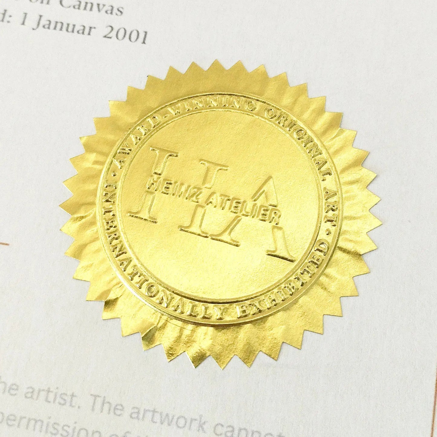 Nahaufnahme des goldfarbenen, geprägten Siegels "HEINZ ATELIER" auf dem Echtheitszertifikat.