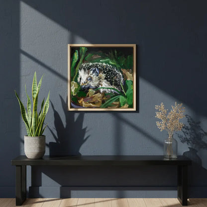 Gerahmtes Acrylgemälde Igel im Laub über schwarzer Bank im Wohnzimmer.